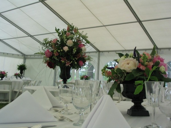 A beautiful wedding reception held in a tent that is decorated with table