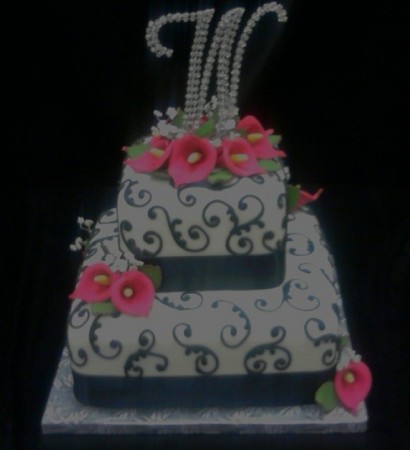 This black white and pink wedding cake features scroll piping and pink 