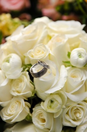 These beautiful wedding rings are placed on top of these wedding flowers for