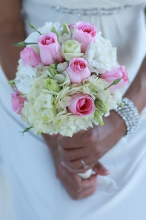 This gorgeous bride is holding a pink cream wedding bouquet filled with 
