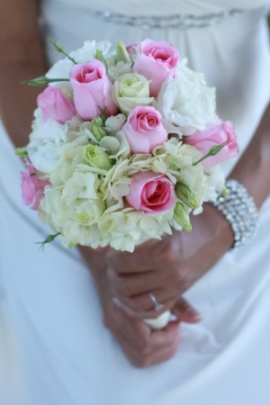 This gorgeous bride is holding a pink cream wedding bouquet filled with