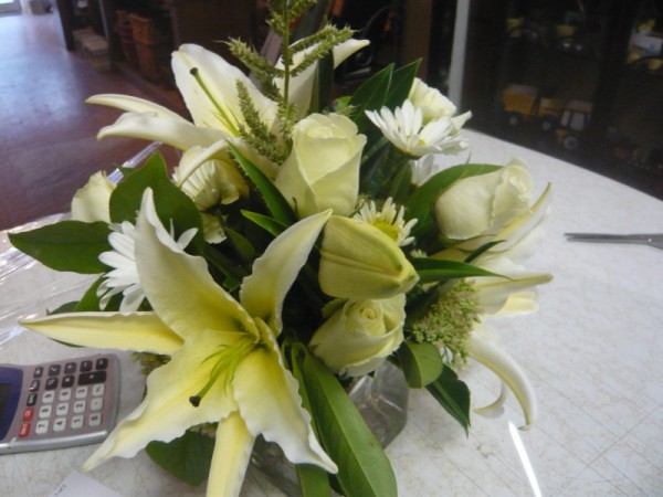A gorgeous reception centerpiece with White Lilies arranged in a glass cube