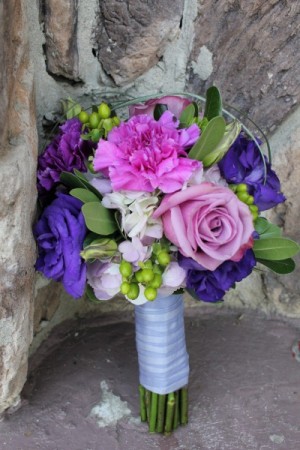 A gorgeous wedding bouquet that features pink and purple flowers