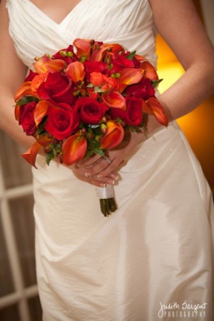 A gorgeous wedding bouquet filled with orange and red flowers