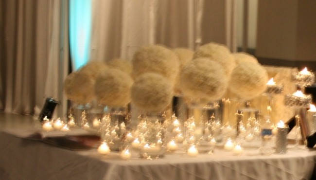  these small votive candles surround white carnation centerpieces