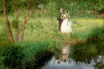 Wedding Couple Poses Next to Pond