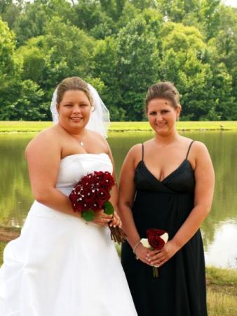 Beautiful Bride with her Bridesmaid with Red Wedding Bouquets